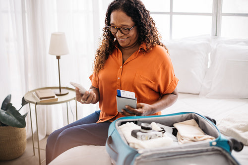 Retired traveler checking her flight details on her phone