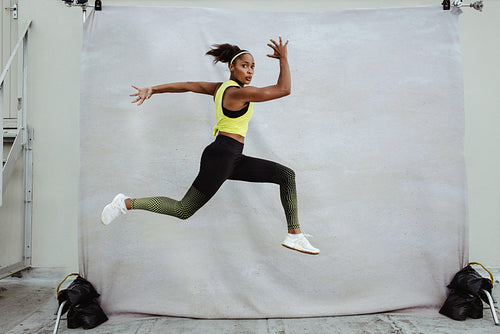 African sportswoman doing running and lunge exercise