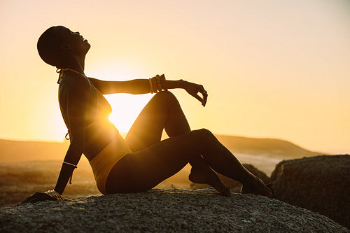 Silhouette of a woman sitting at the beach