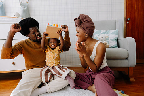 Family joy as baby plays with colorful toy