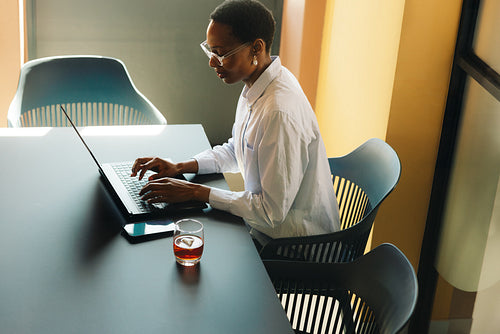 Professional individual working with a laptop in a modern office setting