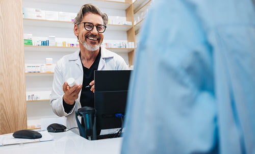 Pharmacist assisting a patient with prescription medication in a chemist