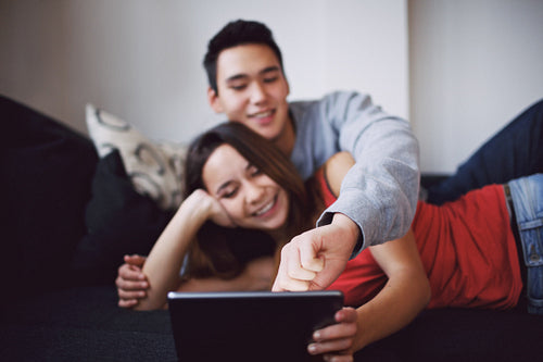 Teenage couple surfing internet on digital tablet