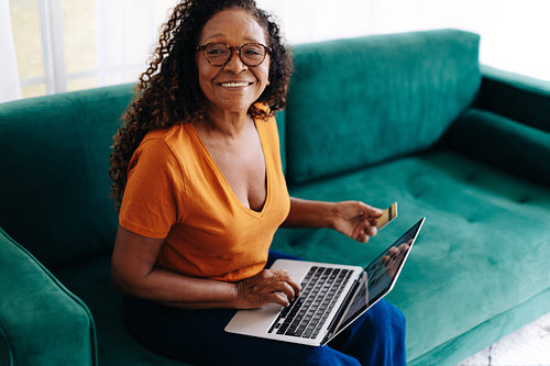 Retired senior woman spoiling herself with online shopping at home