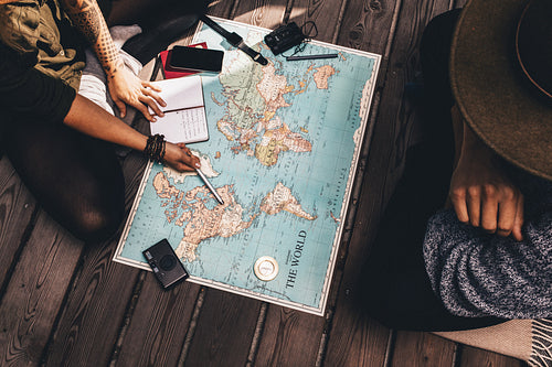 Couple planning vacation using the world map.
