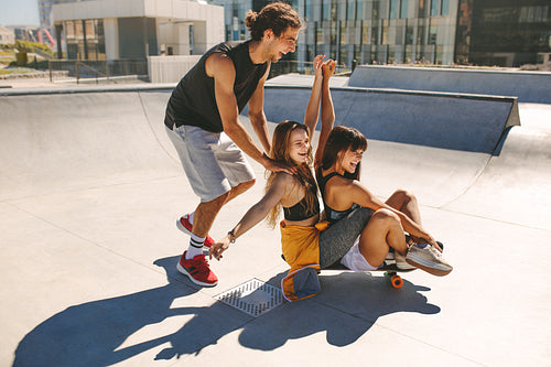 Young people having fun with skateboard in the skate park