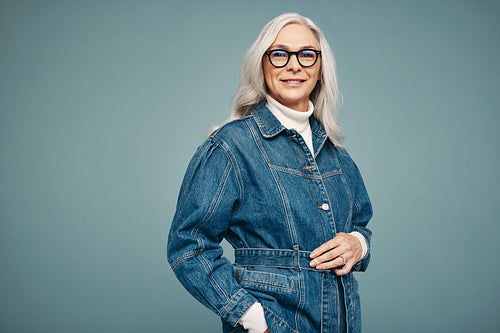 Grey-haired woman standing alone in a studio