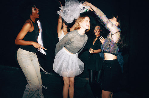 Group of friends dancing and celebrating a special occasion outdoors