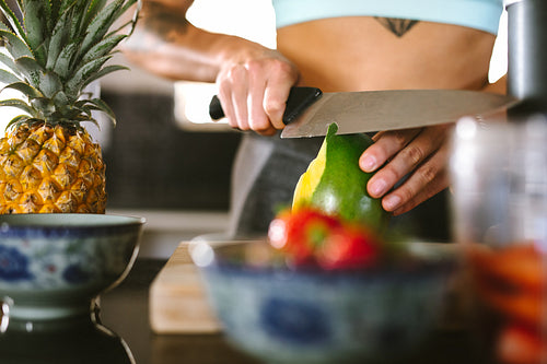 Woman making smoothie in kitchen
