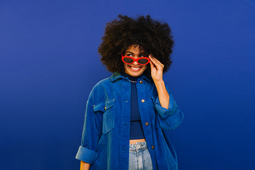 Cheerful young woman looking away while wearing sunglasses