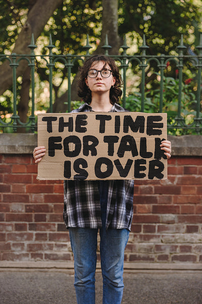 Teenage activist holding a banner outdoors