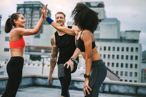 Cheerful women athletes giving high five after workout