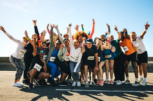Group of diverse runners celebrating after a community event