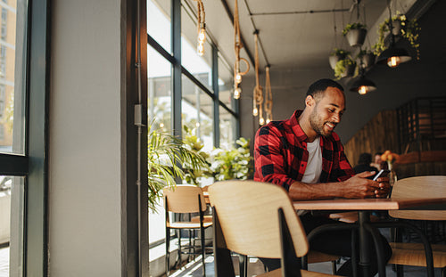 Man sitting at cafe using phone
