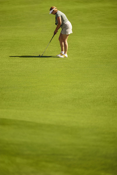 Female golfer skilfully executes a fairway shot