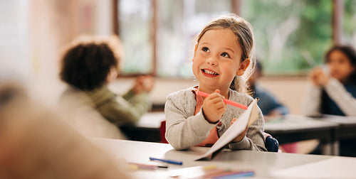 Young girl drawing in classroom during back to school season