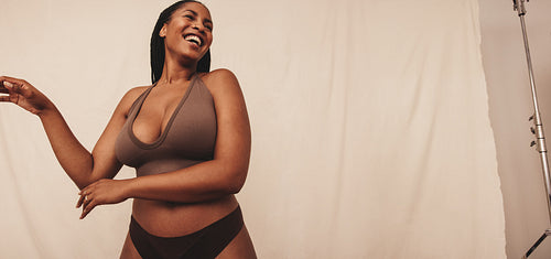 Happy young woman laughing in a studio