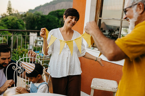 Family prepares for outdoor celebration in garden setting