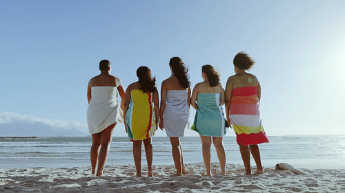 Female friends on the beach doing the mexican wave