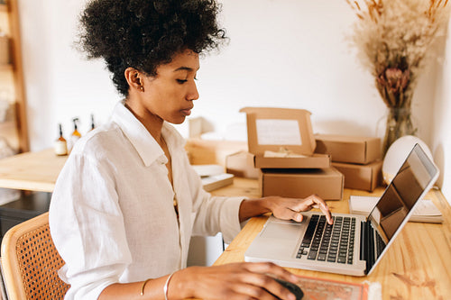 Jewelry designer checking orders on laptop