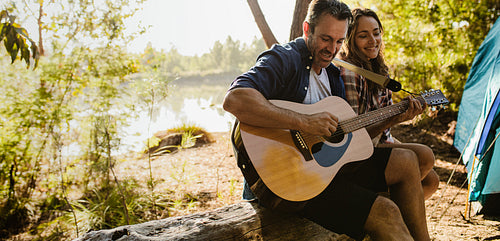 Beautiful couple enjoying camping by the lake
