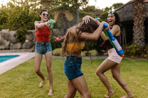 Crazy female friends having water gun battle