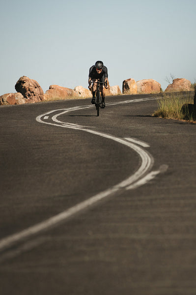 Cyclist cycling down hill on a curvy road