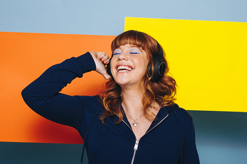 Woman listening to music with headphones in a studio