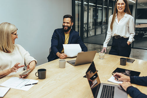 Business professionals laughing during a meeting