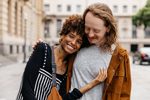 Affectionate embrace on the city streets with smiling couple