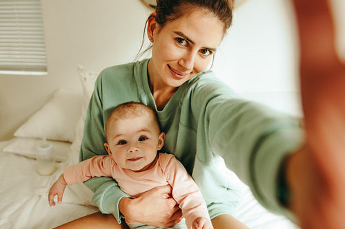 Blogger mom taking a selfie with her baby at home