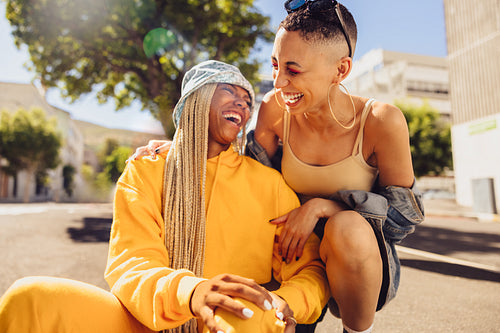 Two female friends laughing cheerfully outdoors