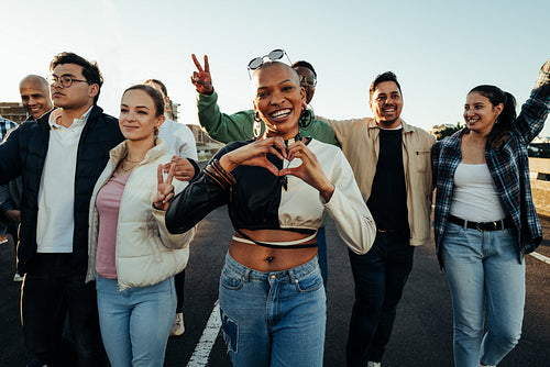 A diverse group of young adults showing unity and positivity outdoors