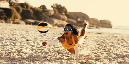 Dynamic beach volleyball player soaring mid-air in summer games