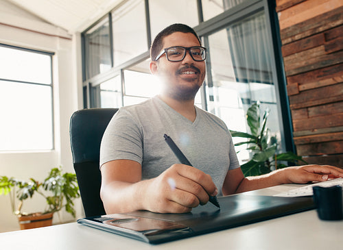 Happy male designer working in office