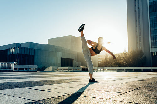 Woman practicing martial arts outdoors