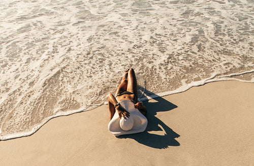 Woman relaxing at the beach wearing sun hat