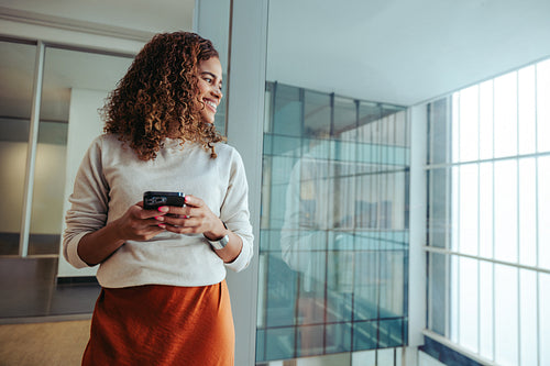 Confident multiracial entrepreneur looking out the window with a sense of accomplishment
