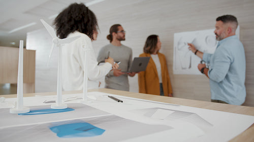 Business professionals reviewing 3D drawings for a wind energy project