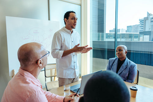 Confident business professional giving a presentation to a diverse team