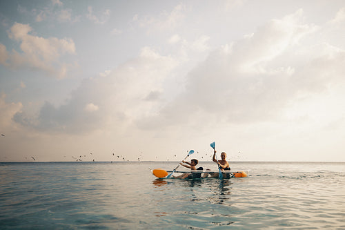 Mother and son kayaking on the ocean during tropical vacation