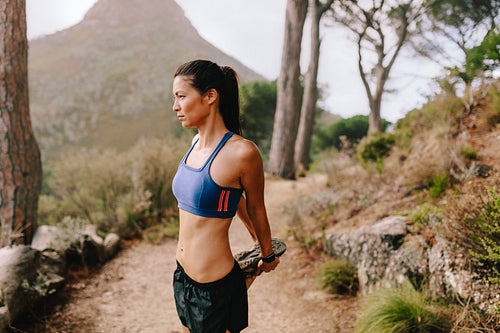 Beautiful young woman exercising on mountain trail