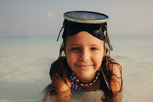 Young girl enjoying a vacation on a tropical island in the shallow waters
