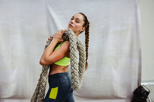 Female athlete with battle rope on rooftop