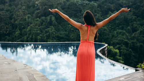 Young woman standing by a swimming pool
