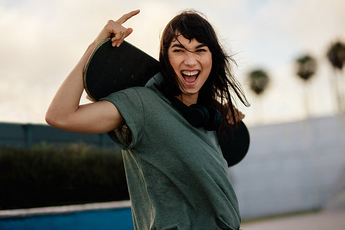 Excited woman skateboarder outdoors at skate park