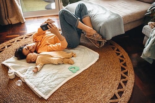 Mother and baby play on rug at home