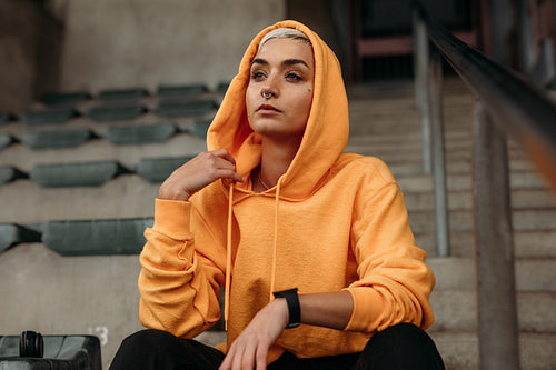 Female athlete sitting in the stands of a stadium