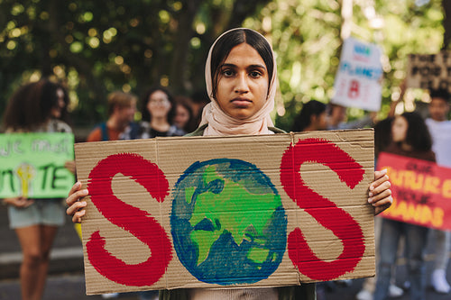 Muslim girl holding a "save our species" banner