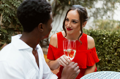 Interracial couple toasting on their dating anniversary